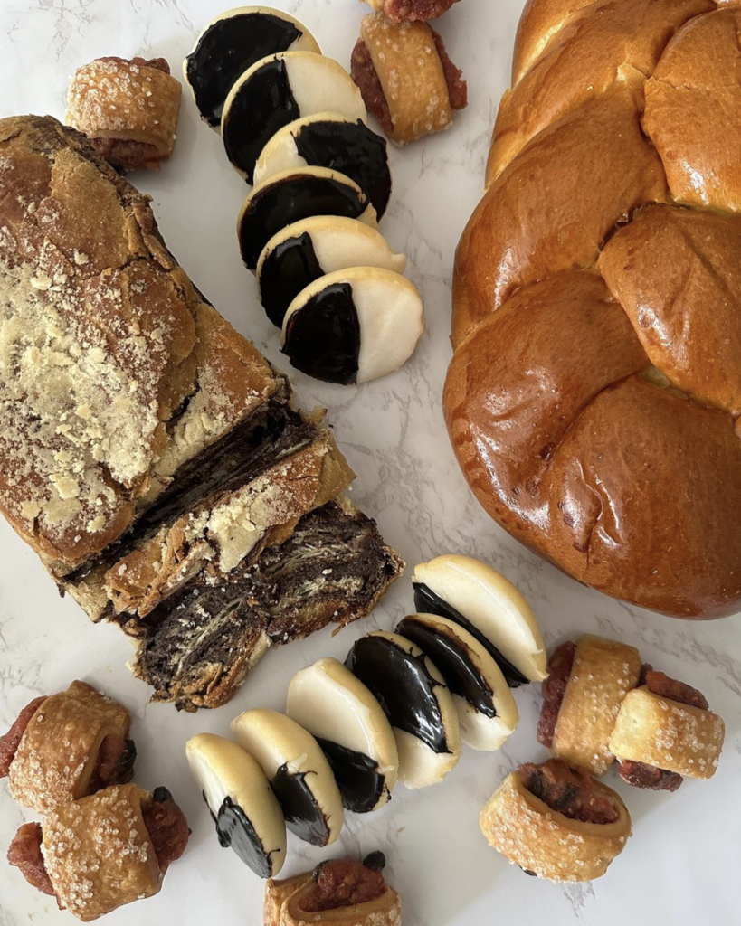 A variety of breads and pastries are arranged on a plate.