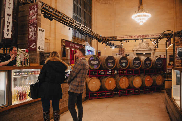 A group of people looking at wine barrels in a store.