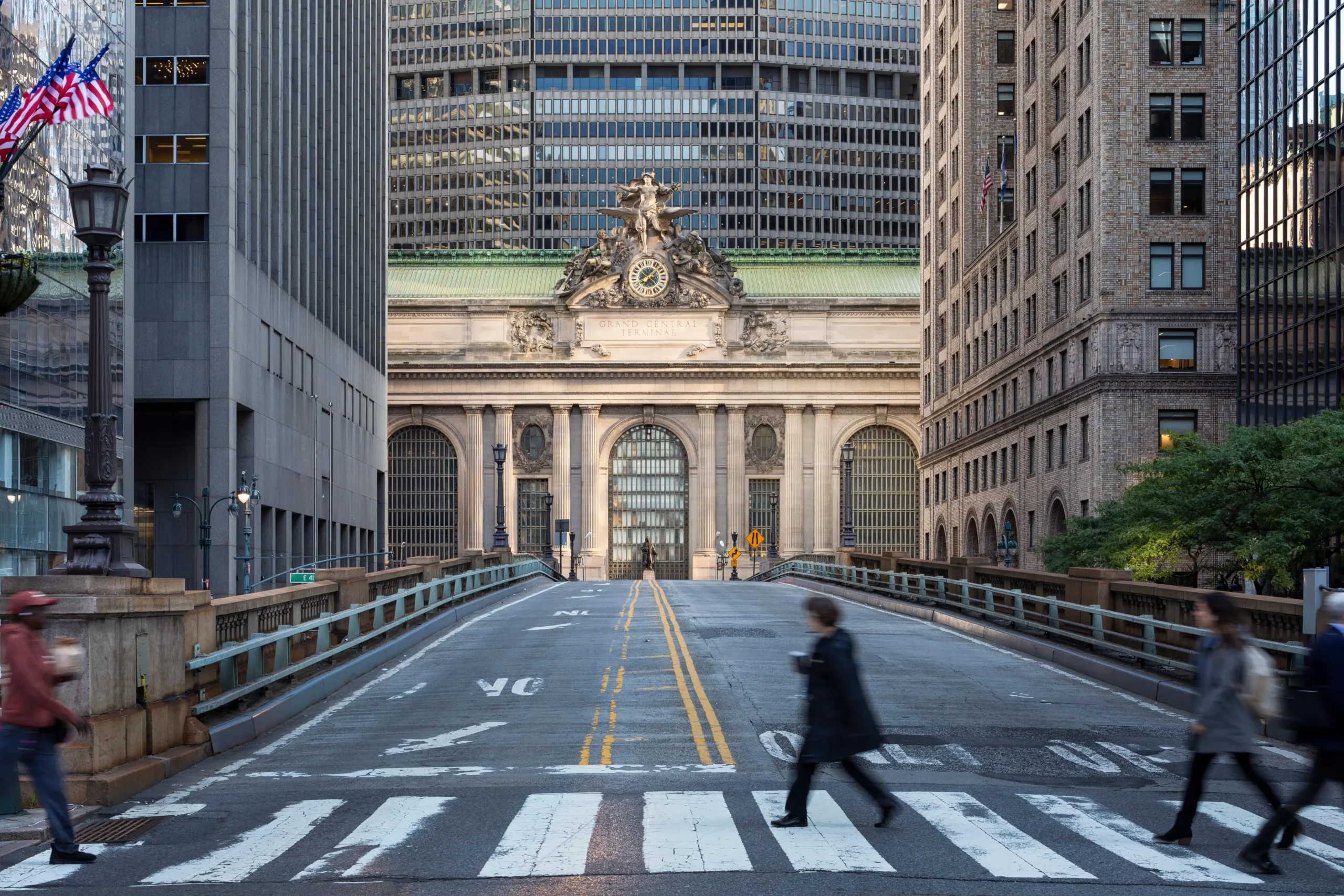 A group of people crossing a street in a city.