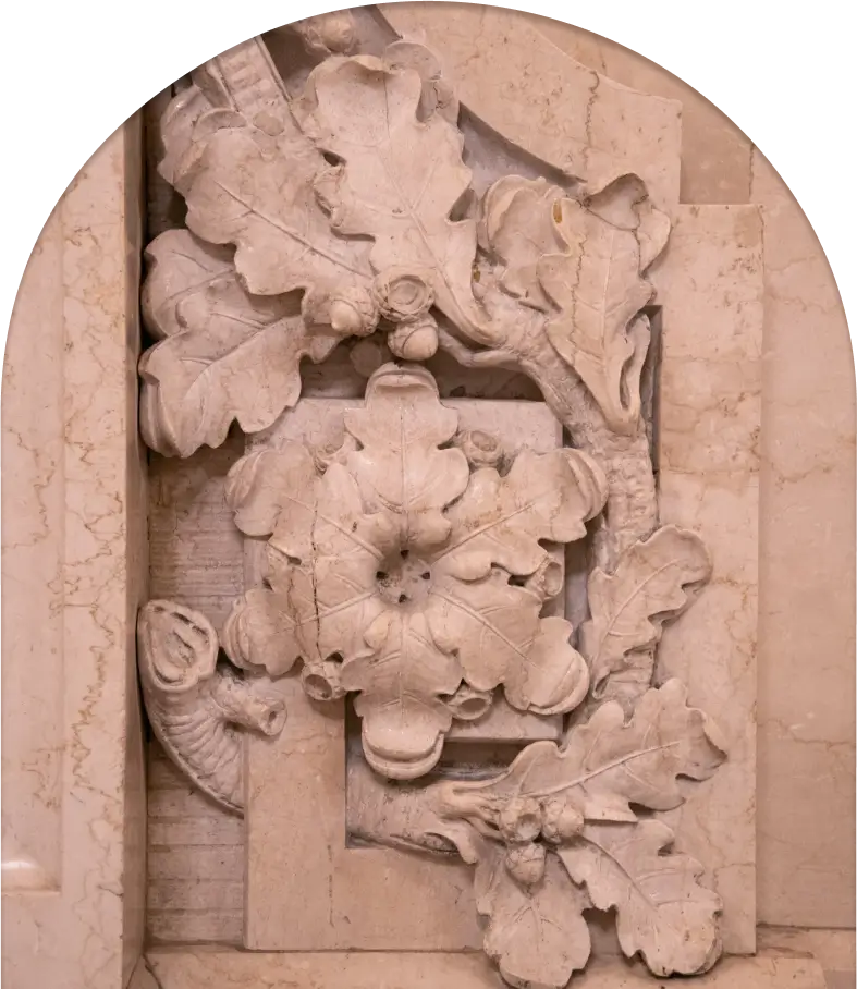 A marble carving of leaves and flowers on a wall.