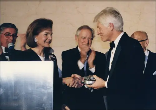 A man and woman shaking hands at a podium.