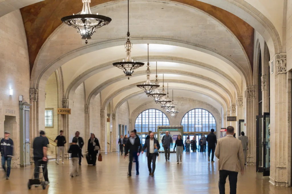 People walking down a hallway in a large building.