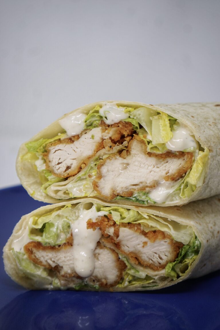 Two chicken wraps on a blue plate.