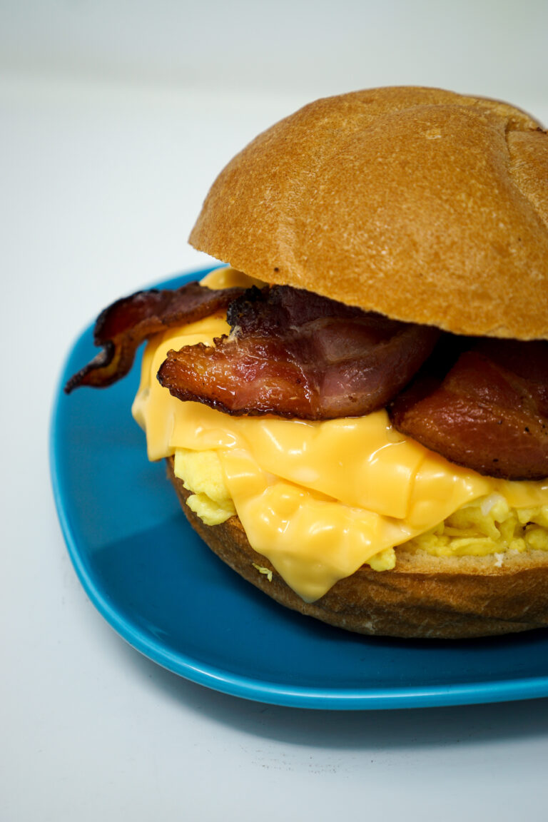 A bacon and egg sandwich on a blue plate.
