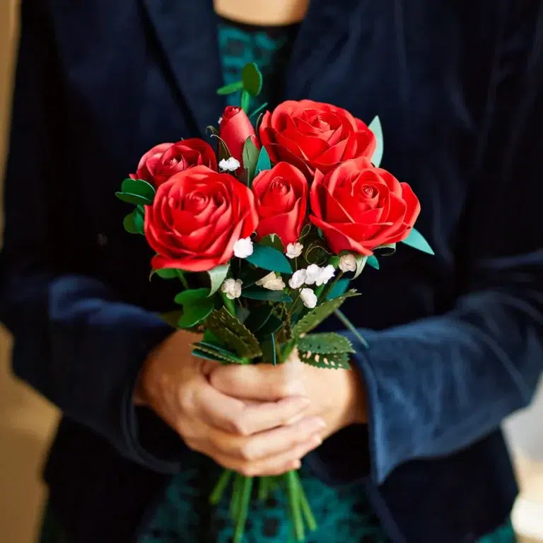 A woman holding a bouquet of red roses.