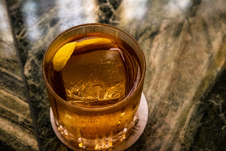 A glass of iced tea on a marble table.