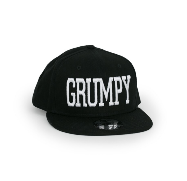 A black snapback hat with the word grumpy on it.