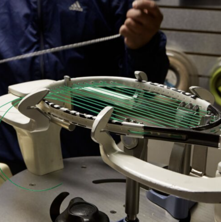 A man is working on a tennis racket in a factory.