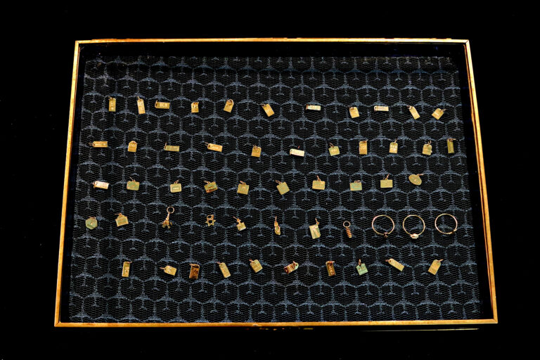 A display of gold earrings in a black box.
